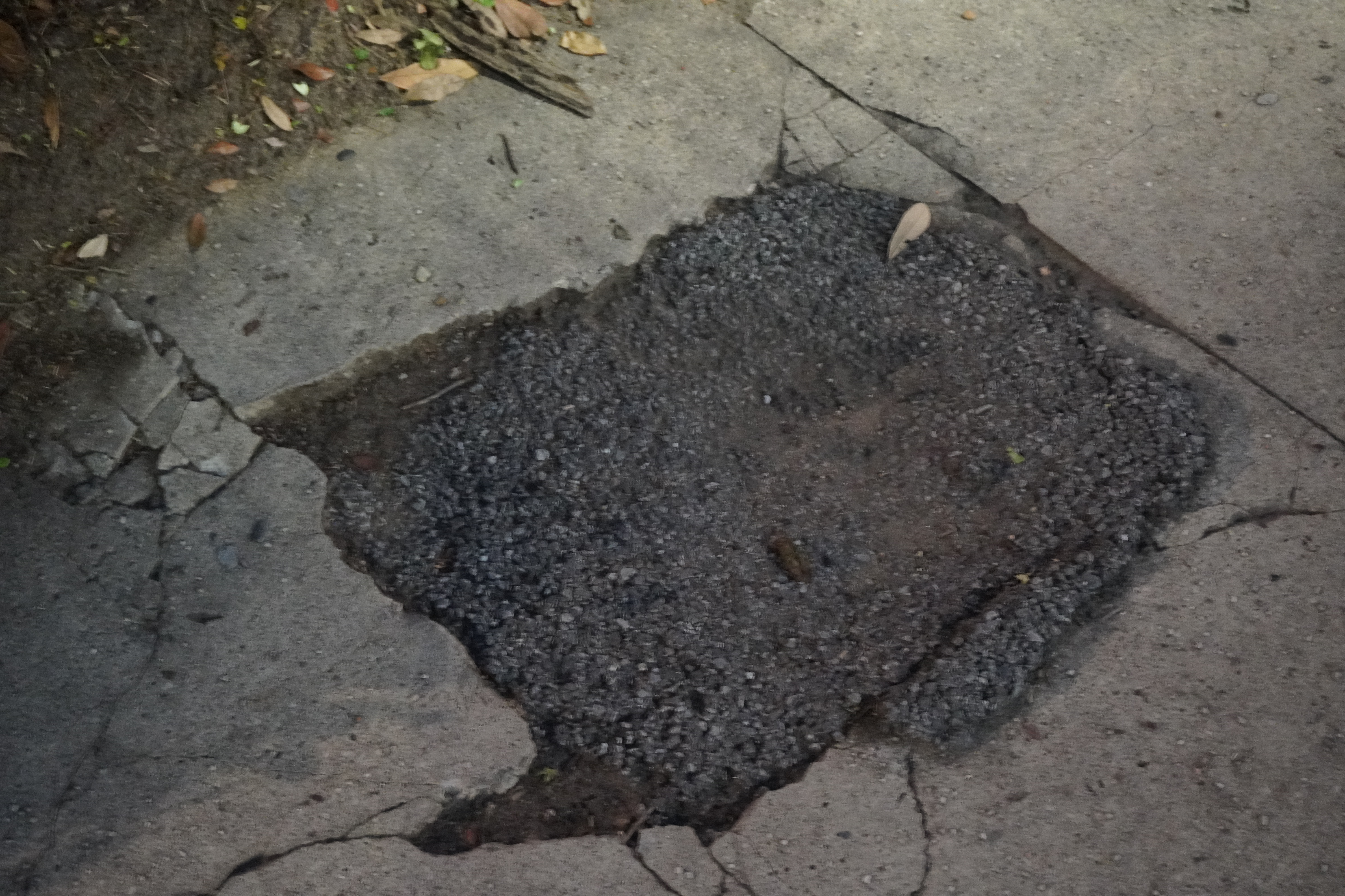 Broken sidewalk with asphalt